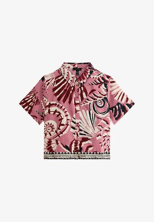 Short-sleeve shirt in pink fabric with abstract tropical print in cream and dark red. Features a button-up front and pointed collar.