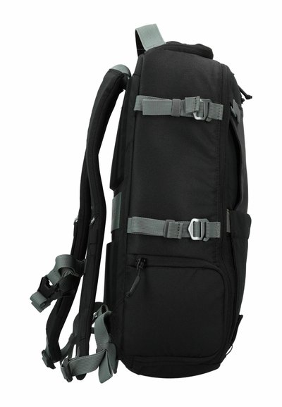 Mochila negra con correas grises, múltiples hebillas, bolsillos con cremallera y correas de hombro acolchadas, construida con tejido duradero.