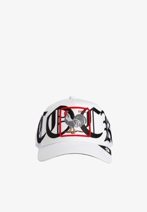 Gorra de béisbol blanca con la palabra "COCK" en letras negras y negrita, y un cuadrado con borde rojo que presenta un gallo gris bordado en la parte frontal.