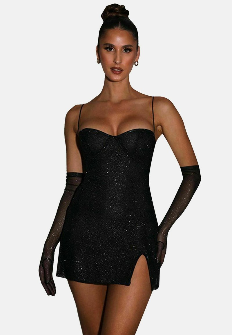 Robe noire courte avec une texture pailletée, présentant un décolleté coeur et des fines bretelles. Inclut des gants transparents noirs et un détail de fente sur le côté.