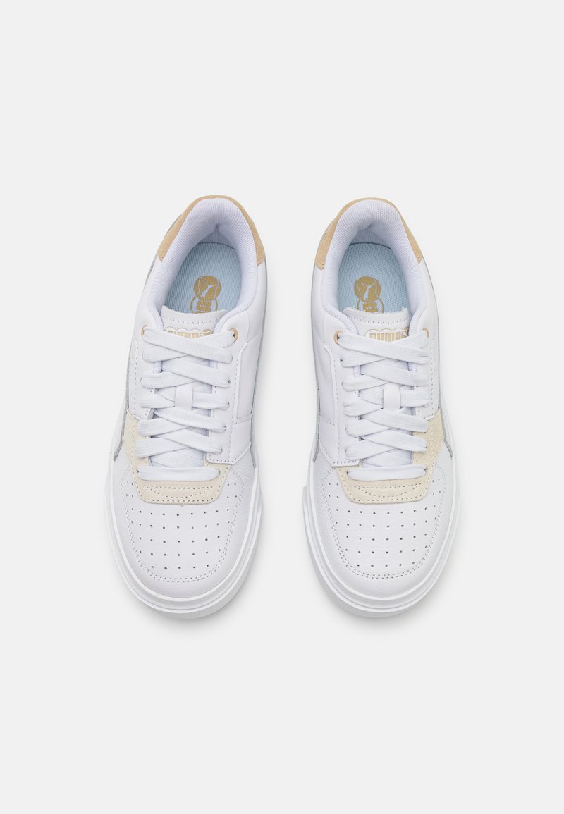 Baskets en cuir blanc avec un bout perforé, des accents couleur crème et des semelles intérieures bleu clair. Présentent des lacets plats blancs et un col rembourré.