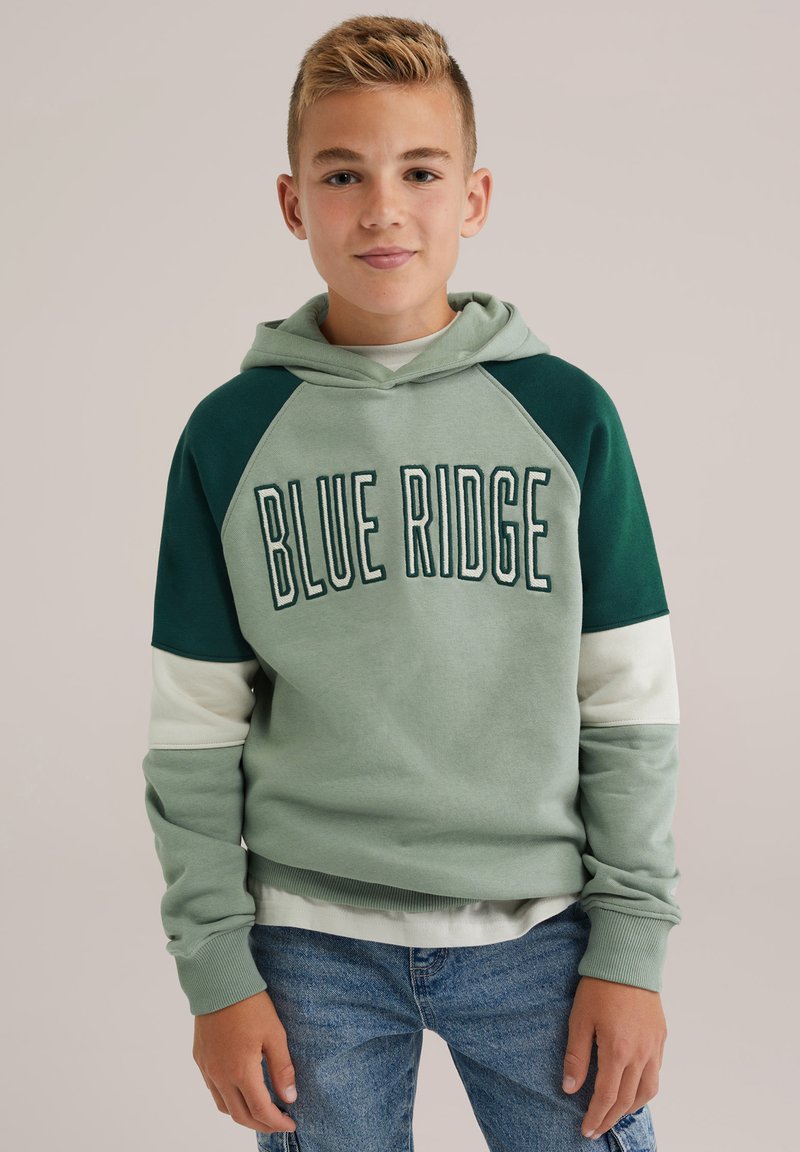 Zelena kapuca z belim in temno zelenim blokovnim dizajnom, besedilom "BLUE RIDGE" na sprednji strani in rebrastimi manšetami. Udoben kroj.