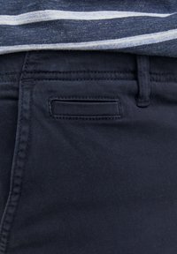 Navy blue pants with a smooth texture, featuring a side pocket, belt loops, and a standard waistband design.