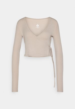 Béžový zavinovací top s dlouhým rukávem a výstřihem do V, vyrobený z žebrované látky, s detailem zavázání v pase a s krátkou délkou.