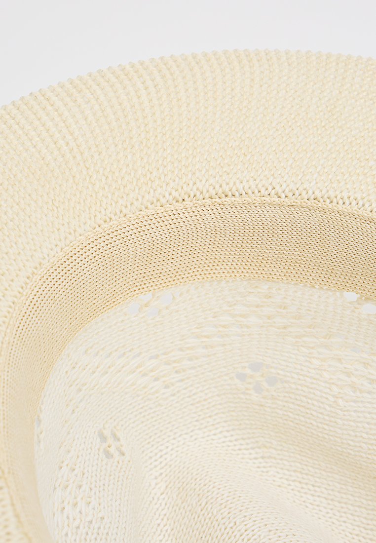Cremfarbener, gewebter Hut mit breiter Krempe. Strukturiertes Strickmuster und Durchbrüche in der Nähe der Krone. Leichtes und flexibles Design.