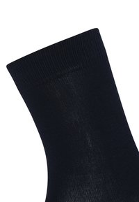 Marine ankelstrømpe lavet af ribbet stof. Har en tætsiddende manchet og en glat struktur, uden mønstre eller synligt hardware.