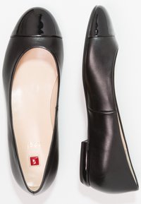 Ballet flats in pelle nera con punta lucida nera, tacco leggero e interno nude. Presentano un piccolo logo rosso vicino alla suola.