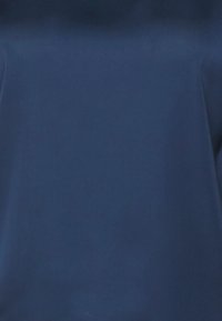 Tessuto blu navy con una texture liscia e opaca, che presenta una superficie solida e uniforme senza motivi o cuciture visibili.