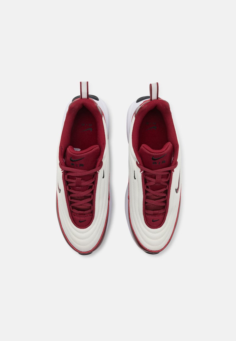 Sneakers Nike bianchi e bordeaux con tomaia texture, punta rotonda, colletto imbottito e accenti del logo neri. Presentano una chiusura con lacci e una suola a contrasto.