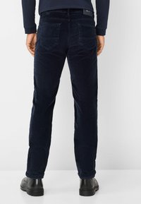 Marineblauwe corduroy broek met een recht model, voorzien van twee achterzakken en een zwart etiket op de tailleband. Glad textuur en casual pasvorm.