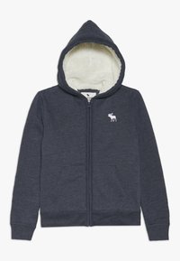 Felpa con zip di colore navy, con un interno morbido bianco, due tasche frontali e un piccolo logo di alce bianco sul petto. Presenta un cappuccio con coulisse.