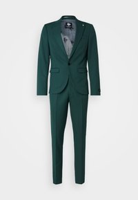 Costume vert foncé avec une coupe ajustée, blazer à un bouton avec revers classiques et pantalon assorti. Tissu texturé avec une doublure intérieure lisse.