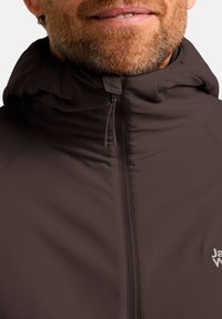 Veste à capuche marron avec fermeture éclair à l'avant, tissu texturé et logo sur la poitrine. La capuche dispose de cordons de serrage ajustables pour un meilleur ajustement.