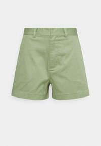 Shorts di cotone verde chiaro con parte anteriore piatta, passanti per cintura e taglio dritto. Presentano una zip nascosta e una texture liscia.