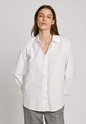 Witte lange mouwen shirt van katoen, met een knoopsluiting aan de voorkant, een ontspannen pasvorm en subtiele geborduurde details bij de borst.