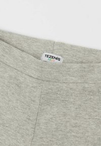 Grijs geribbeld stof met een zachte textuur, uitgerust met een platte tailleband en een label met de tekst "TEZENIS KIDS." Geschikt voor kinderen.