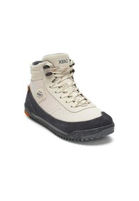 Zapato de senderismo Xero de caña alta en beige y negro, con cordones, suela texturizada y parches con el logotipo en el costado y la lengüeta.