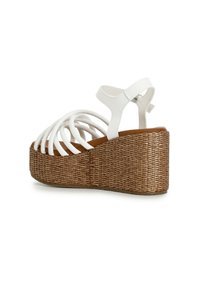 Sandali platform bianchi con tacco a zeppa intrecciato marrone, design con punta aperta e multiple cinghie incrociate per supporto e traspirabilità.