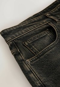 Svarte denimjeans med en falmet tekstur, fem-lomme design og synlig syning. Inkluderer en lille baglomme detalje.
