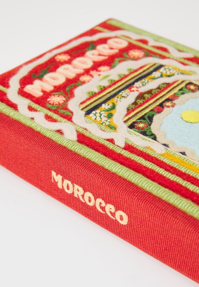 Kniha pokrytá červenou látkou s vyšitými detailmi, zobrazuje farebné kvetinové vzory a slovo "MAROKO" v smotanovom stehu na chrbte.