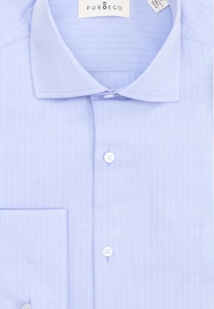 Camisa de vestir azul claro para hombre con cuello puntiagudo, botones blancos, bolsillo en el pecho izquierdo y etiqueta de la marca PURDEGO en el interior del cuello.