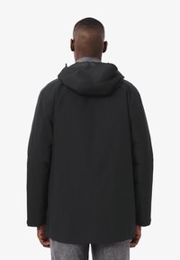 Giacca impermeabile nera con cappuccio, caratterizzata da un taglio dritto, maniche lunghe e una texture liscia. Design semplice senza dettagli aggiuntivi.