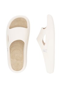 Sandales blanches à enfiler avec une ouverture à l'avant, semelle intérieure beige rembourrée, côtés découpés et semelle texturée comportant un petit logo sur le côté.