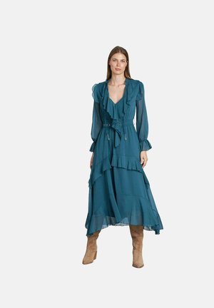 Vestido en tonos verde azulado, de corte en capas con mangas rizadas y escote en V. Fabricado con una tela ligera; cuenta con una cintura ajustable con cordón y un corte fluido.