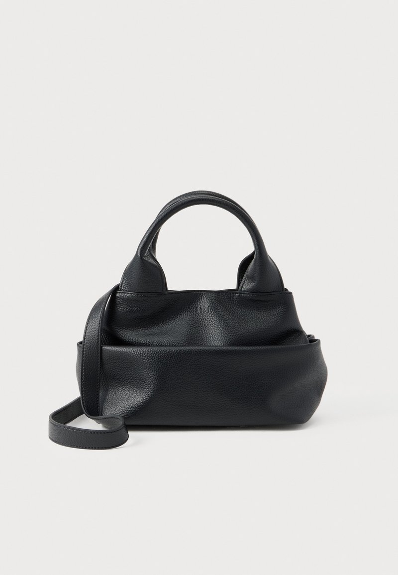 Μαύρη τσάντα χειρός από δέρμα με υφή, με στρογγυλεμένες λαβές και μακρύ λουρί ώμου, εκτεθειμένη σε λευκό φόντο.