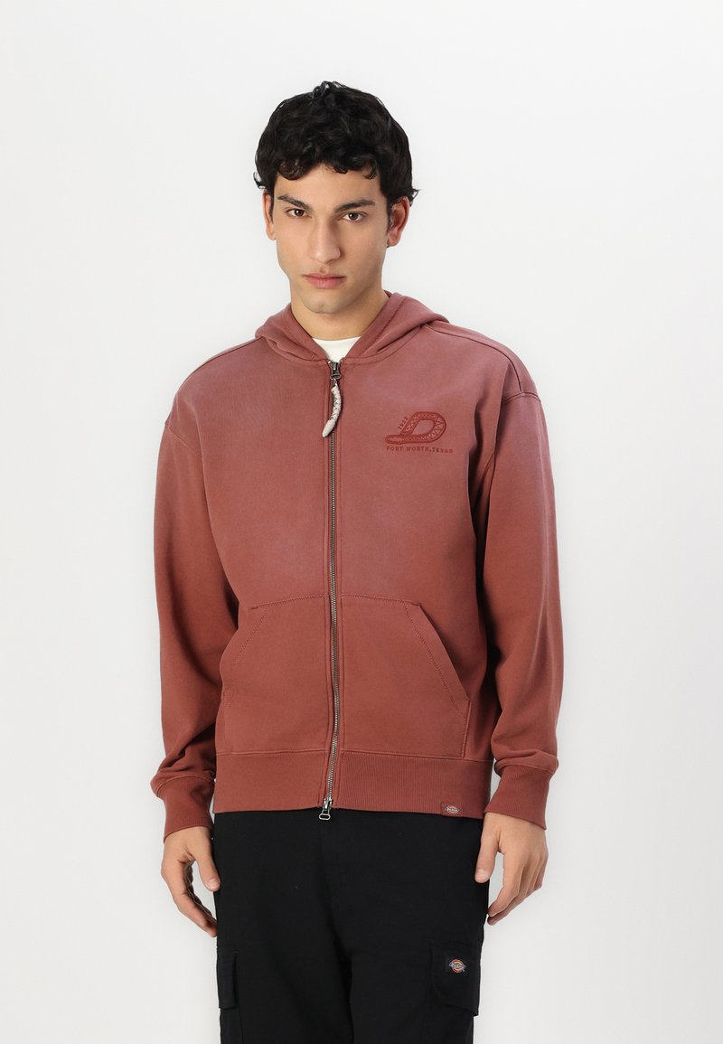 Bordo zip-up gobtuvė su priekinėmis kišenėmis, šonkauliniais rankogaliais ir apatine dalimi. Yra logotipas ant krūtinės ir raištelis ant gobtuvo. Pagaminta iš medvilnės mišinio.