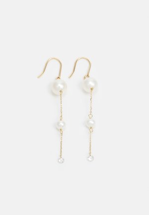 Boucles d'oreilles dorées avec trois perles blanches sur des chaînes, deux accents de cristal clair en bas, design pendulaire.