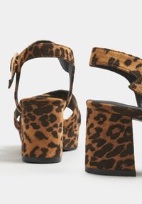 Czarno-żółte szpilki na platformie z zamszowego wykończenia, z szerokim paskiem nad palcami, regulowanym paskiem na kostkę oraz masywnym słupkowym obcasem.