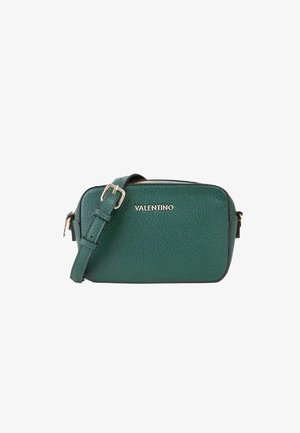 Sac bandoulière en cuir texturé vert avec fermeture éclair et bandoulière ajustable, arborant un logo argenté sur le devant.