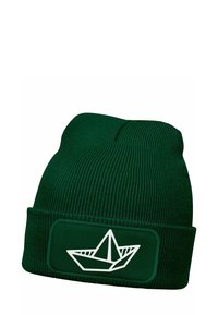 Green knitted beanie with a ribbed texture. Features a white paper boat design on a rectangular patch. Classic fold-up style.