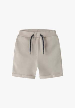 Shorts en coton beige avec une taille à cordon, des liens bleu foncé et des revers roulés ornés d'une bande d'accent texturée à l'ourlet.
