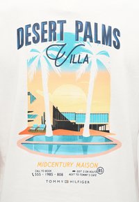 Έπαυλη στην έρημο με δύο ψηλές φοινικιές, μοντέρνο σπίτι μέσης του αιώνα, πισίνα και ηλιοβασίλεμα σε ζεστές αποχρώσεις μπλε, πορτοκαλί και κίτρινου.