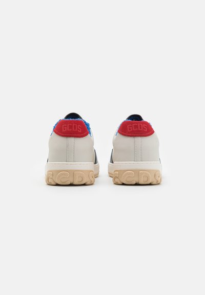 Baskets en cuir blanc avec des accents en fourrure bleue au talon et un logo rouge. Semelle texturée beige avec des détails "GCDS". Conçues pour un usage décontracté.