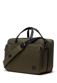 Sac en toile vert olive avec des anses noires, de forme rectangulaire, doté de plusieurs compartiments et d'une texture lisse avec des accents de logo.