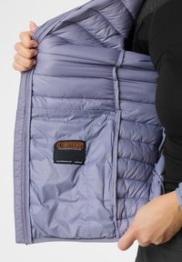 Light purple, insulated jacket with a quilted pattern, featuring an inner pocket and a tag from Thermore. Smooth, synthetic texture.