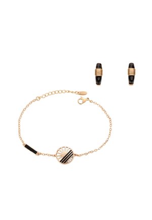Złota bransoletka z łańcuszkiem z okrągłym czarno-złotym geometrycznym zawieszką oraz pasujące małe czarno-złote kolczyki koła.
