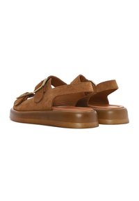 Brown suede sandals with an open design, featuring wide straps, gold hardware accents, and a thick, textured tan sole.