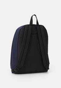 Ryggsäck med en tvåfärgad design i marinblått med svarta vadderade axelremmar; strukturerad tyg, topphandtag för bärande.