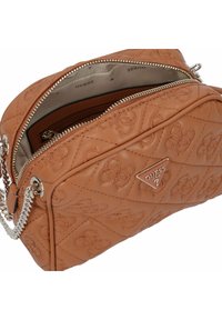 Braune gesteppte Handtasche aus synthetischem Leder mit silbernem Zubehör. Verfügt über ein Logo-Badge, einen Reißverschluss und ein Stofffutter.