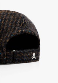 Chapeau en laine avec un motif en tweed brun foncé et bleu. Comprend une sangle réglable et un logo de crâne blanc au dos.