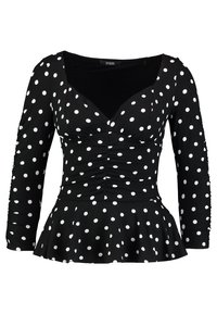 Zwarte lange mouw top met witte stippen, V-hals, ruches aan de voorkant en een uitlopende peplumzoom. Gemaakt van een rekbare stof.