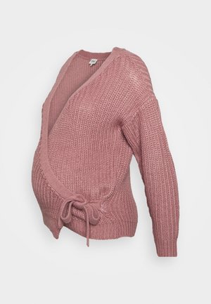 Roze gebreide zwangerschapswikkeltrui met lange mouwen en een striksluiting aan de voorkant, weergegeven op een witte achtergrond.