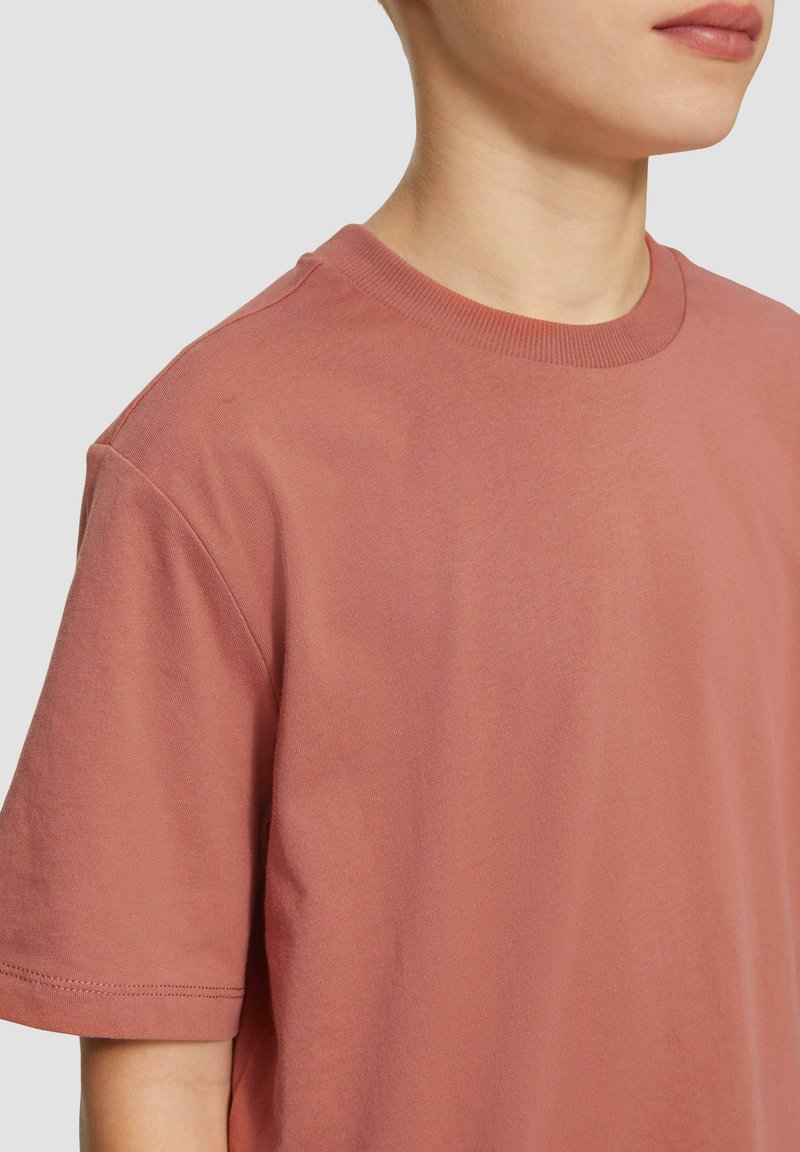 Korte mouwen, ronde hals t-shirt in zachte, stofroze katoen. Heeft een gladde textuur met een schone zoom en minimale naden.