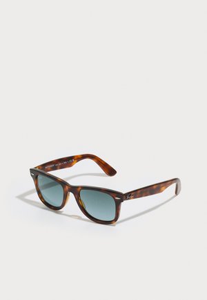 Brown tortoiseshell sunglasses with rectangular frames, green lenses, and silver accents on the brow and sides. Made in Italy.