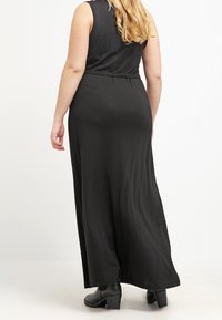 Black maxi dress with a sleeveless design, cinched waist, and flowing fabric; smooth texture with no visible patterns or embellishments.