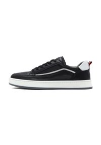 Czarne skórzane sneakersy z tonalnym przeszyciem, białą podeszwą środkową oraz kontrastowymi szarymi i czerwonymi akcentami na pięcie. Posiadają zaokrąglony czubek i sznurowaną konstrukcję.
